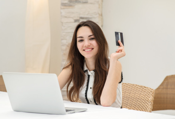 Online shopping. Young and pretty girl sitting at a laptop and m